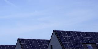 drei versetzt hintereinanderstehende Einfamilienhäuser mit Photovoltaikanlagen auf den Satteldächern